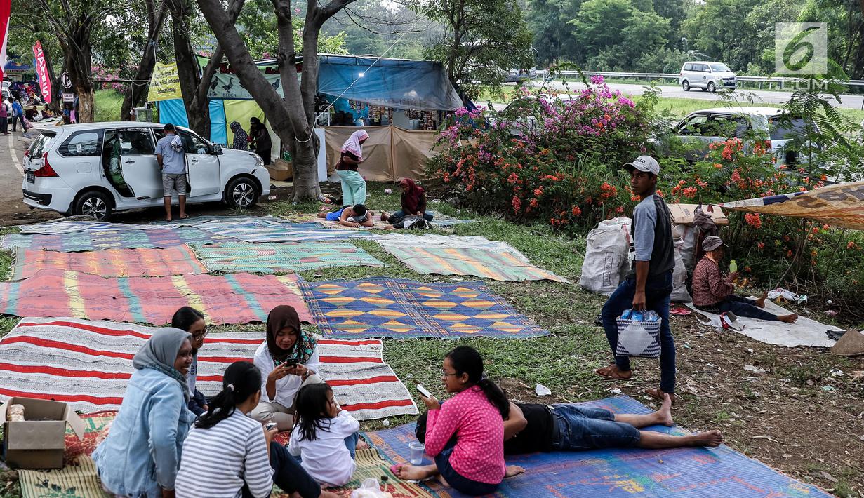 Sejumlah pemudik beristirahat sejenak di halaman rest area Tol Timur - Palimanan - Kanci,  Cirebon, Jawa Barat, Sabtu (1/7). Pada H+6 Lebaran pengguna jalan tol memanfaatkan rest area untuk makan, tidur sejenak. (Liputan6.com/Faizal Fanani)