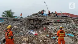 Anjing polisi K-9 mengendus bangunan yang runtuh akibat gempa bumi saat proses pencarian korban di Rumah Sakit Mitra Manakarra di Mamuju, Minggu (17/1/2021). Polri mengerahkan enam ekor K-9 untuk membantu menangani dampak gempa di Majene dan Mamuju, Sulawesi Barat. (Liputan6.com/Abdul Rajab Umar)