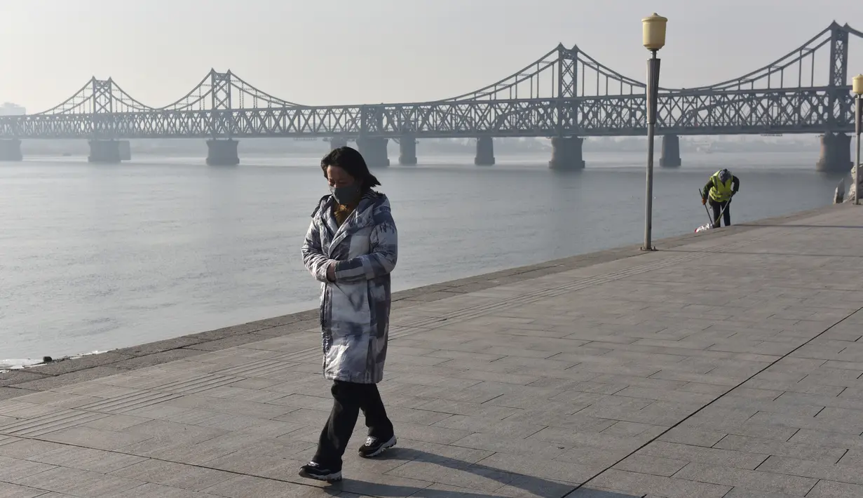 Seorang wanita di dekat Jembatan Persahabatan di kota Dandong di provinsi Liaoning, China (22/2). Jembatan Persahabatan merupakan salah satu dari beberapa cara untuk memasuki atau meninggalkan Korea Utara. (AFP Photo/Greg Baker)