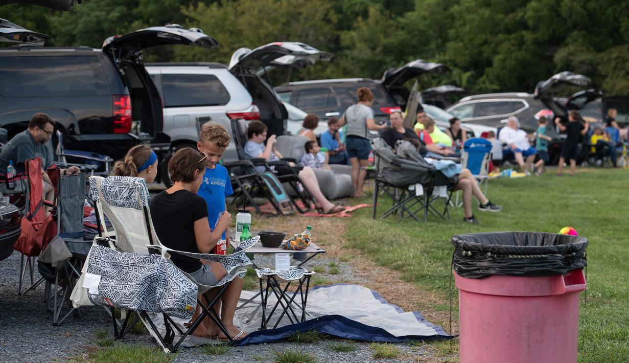 Orang-orang menghadiri pemutaran film drive-in di Union Market, Washington, 3 Agustus 2018. Menonton film di luar ruangan atau drive-in merupakan bagian penting dalam industri hiburan di Amerika. (AFP PHOTO/Nicholas Kamm)