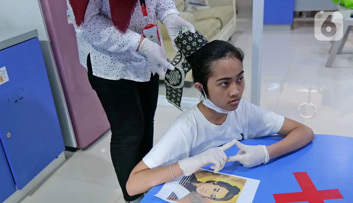Siswi SMP inklusif atau berkebutuhan khusus Luna sedang disanggul ala Cut Nyak Dien.  (Liputan6.com/Herman Zakharia)