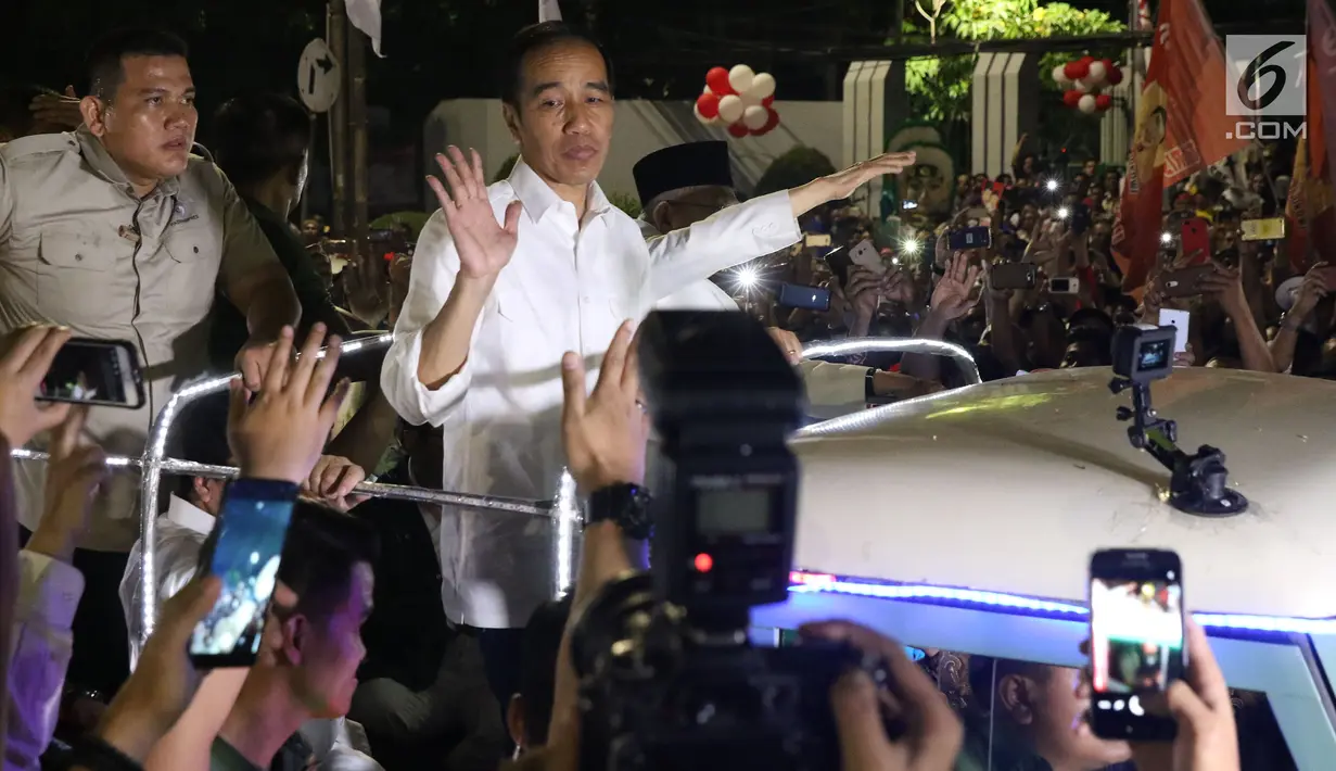Calon Presiden RI Petahana, Joko Widodo bersama Cawapres Ma’ruf Amin menyapa pendukungnya saat berada di atas jeep menuju gedung KPU dari Tugu Proklamasi, Jakarta, Jumat (21/9). (Liputan6.com/Helmi Fithriansyah)
