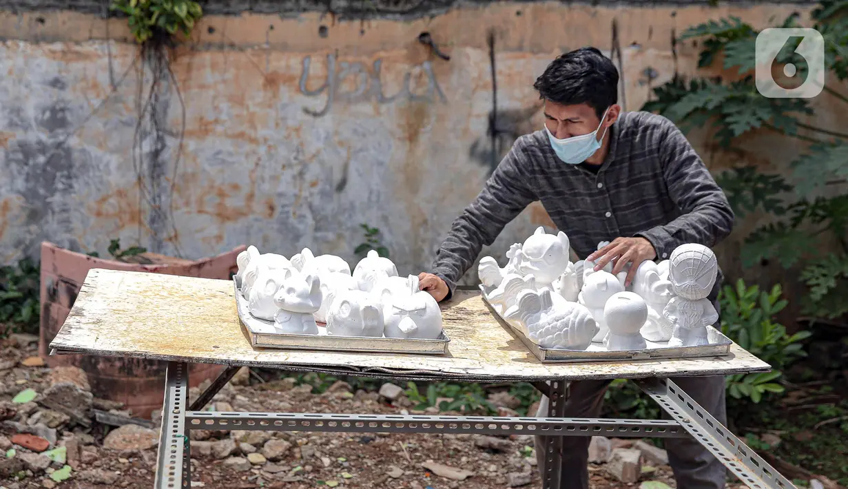 Pekerja menjemur boneka karakter kartun di Saung Art Gallery, Pondok Cabe, Tangerang Selatan, Banten, Kamis (6/1/2022). Selain menjadi sarana edukasi, boneka berbahan gipsum yang dapat digunakan sebagai celengan ini dijual dengan harga Rp 20 ribu-Rp 40 ribu per buah. (Liputan6.com/Faizal Fanani)