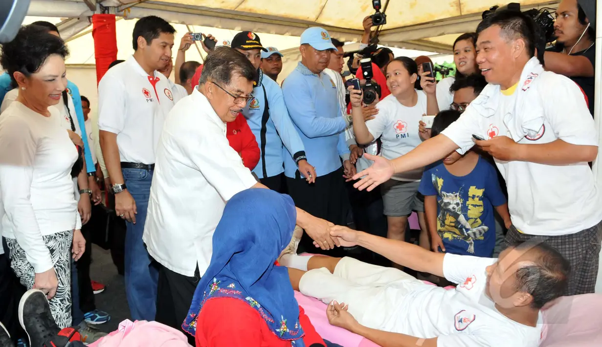 Wakil Presiden Jusuf Kalla bersalaman dengan salah satu pendonor darah di Bundaran HI, Jakarta, Minggu (29/3/2015). Acara donor darah diadakan serentak di 25 kota di tanah air bertujuan membudayakan aksi donor darah. (Liputan6.com/Panji Diksana)