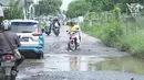 Kendaraan melintasi jalan yang rusak di Jalan Raya Gas Alam, Depok, Jawa Barat, Selasa (7/5). Kondisi jalan yang tidak kunjung diperbaiki tersebut menjadi kubangan air setiap hujan serta berbahaya bagi keselamatan pengguna jalan. (Liputan6.com/Immanuel Antonius)