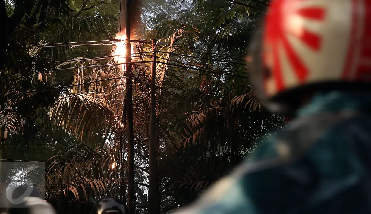 Percikan api yang keluar dari kabel listrik setelah hujan deras mengguyur sore ini, di Jalan Imam Bonjol No 2, Jakarta, Selasa (28/3). Lokasi tiang listrik yang terbakar itu berada di dekat Kedutaan Besar Amerika Serikat. (Liputan6.com/JohanTallo)