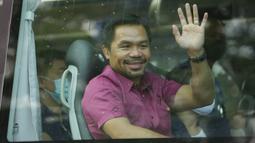 Pensiunan bintang tinju dan senator Filipina Manny Pacquiao melambai dari kendaraannya sebelum mengajukan sertifikat pencalonannya untuk pemilihan presiden tahun depan di Komisi Pemilihan Umum, Manila, Filipina, Jumat (1/10/2021). (AP Photo/Aaron Favila)