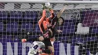 Kiper Real Valladolid, Jordi Masip, berebut bola dengan pemain Real Madrid, Mariano Diaz, pada laga Liga Spanyol di Stadion Jose Zorrila, Minggu (21/2/2021). Real Madrid menang dengan skor 1-0. (AP/Alvaro Barrientos)