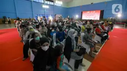 Warga menunggu saat gelaran Vaksin Covid-19 Serentak di GOR Radio Dalam, Jakarta Selatan, Selasa (8/3/2022). Vaksinasi tersebut serentak digelar di seluruh Indonesia yang diselenggarakan Kepolisian RI dengan target penyaluran vaksin sebanyak 1.114.750 dosis. (Liputan6.com/Herman Zakharia)