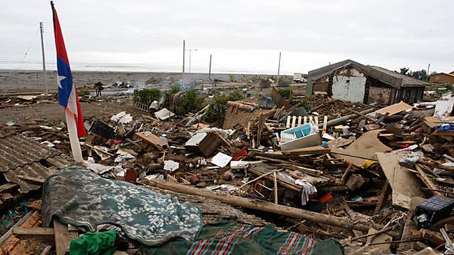 Sebuah bendera Chile berdiri di tengah puing-puing di Iloca, Chili, Senin, setelah gempa berkekuatan 8,8 menghantam Chili awal Sabtu.