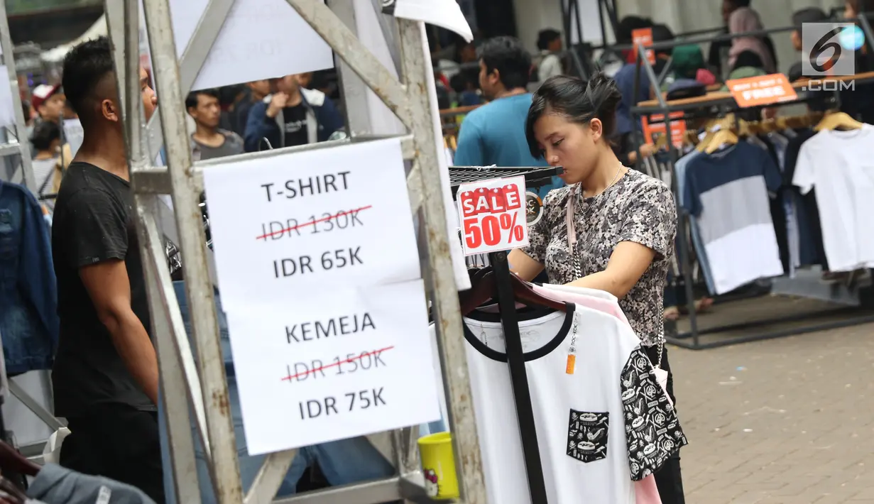 Pengunjung memilih busana yang ditawarkan pada gelaran Jakcloth Year End Sale di Parkir Timur Senayan, Jakarta, Sabtu (22/12). 380 tenant yang menawarkan beragam busana yang rata-rata menyasar pembeli berusia remaja. (Liputan6.com/Helmi Fithriansyah)