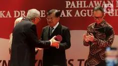 Wakil Presiden ke-10 dan ke-12 RI Jusuf Kalla (tengah) menerima anugerah dari Pembina Yayasan Sekar Manggis Anak Agung Gde Agung saat penyerahan penghargaan Anugerah Dr Ide Anak Agung Gde Agung di Kantor Kementerian Luar Negeri, Jakarta, Kamis (23/1/2020). (Liputan6.com/Faizal Fanani)