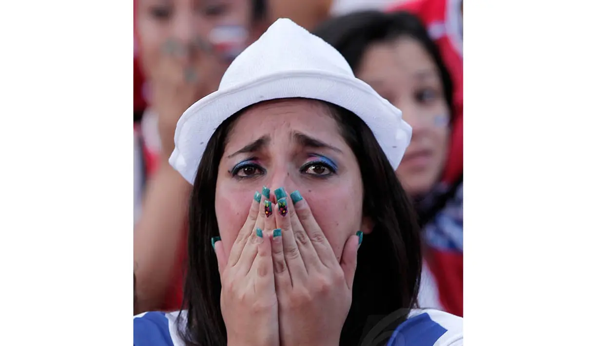 Usai dikalahkan Belanda, seorang wanita tampak bersedih atas kekalahan tim Kosta Rika, Brasil, Sabtu (5/7/14). (REUTERS/Juan Carlos Ulate)