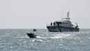 Sebuah kapal permukaan tak berawak (USV) T-12 Man-Portable Tactical Autonomous Systems (MANTAS) berlayar di perairan Teluk di depan kapal Penjaga Pantai Bahrain saat latihan angkatan laut bersama antara Komando Armada ke-5 AS dan pasukan Bahrain, 26 Oktober 2021. (MAZEN MAHDI/AFP)