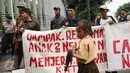 Seorang anak melintas di depan pengunjuk rasa di Kedubes Belanda di Jakarta, Rabu (23/11). Mereka meminta pemerintah Belanda menghentikan upaya mendorong investasi dalam pembangunan infrastruktur di Teluk Jakarta. (Liputan6.com/Helmi Fithriansyah)