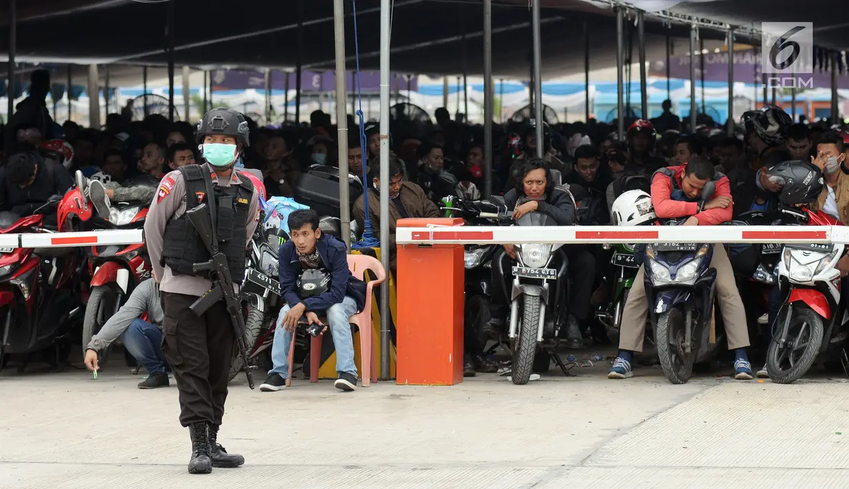 Polisi menjaga pemudik untuk dipindahkan dari Dermaga 6 ke Dermaga 1-5 di Pelabuhan Merak, Banten, Jumat (23/6). H-2 Lebaran 2017, ribuan pemudik bermotor memadati Dermaga 6 Pelabuhan Banten. (Liputan6.com/Helmi Fithriansyah)