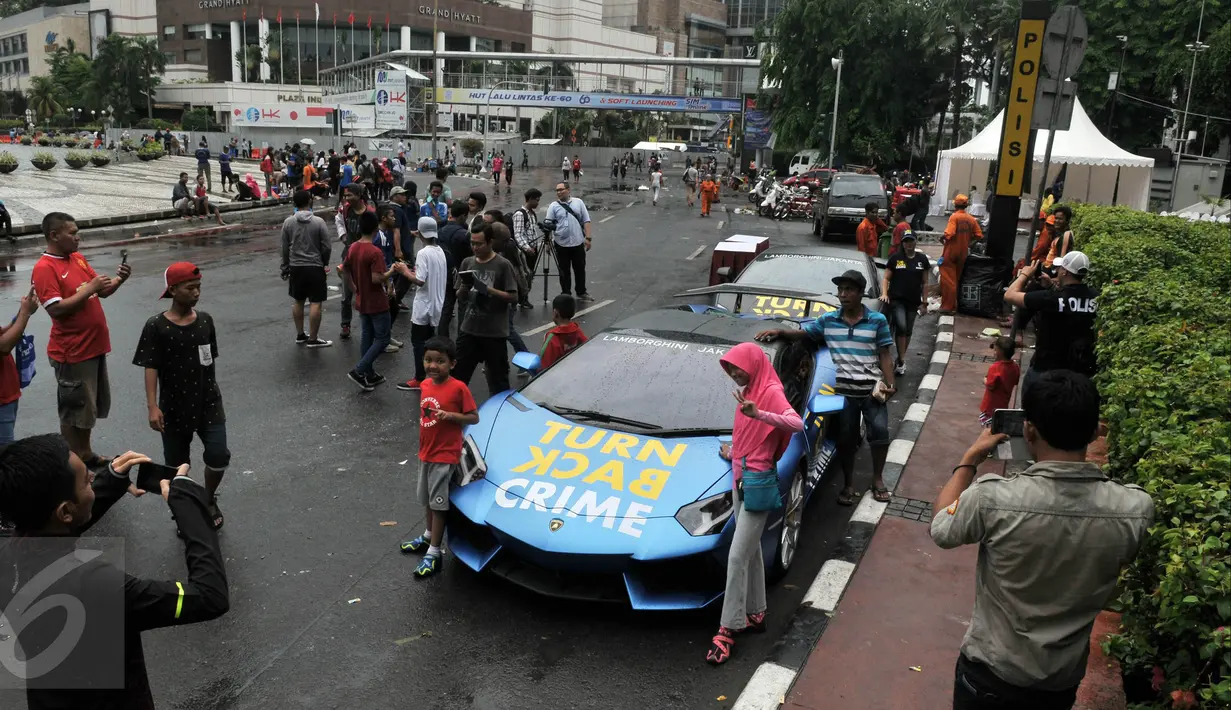 mlah warga melakukan foto di samping mobil Lamborghini di Bundaran HI, Jakarta, Minggu  (29/11/2015). Dua Lamboghini ini sengaja parkir untuk kampanye memerangi kejahatan karena di Ibukota. (Liputan6.com/Johan Tallo)