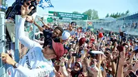 Pebalap Mercedes, Lewis Hamilton, berfoto bersama penonton setelah memenangi balapan F1 GP Kanada, Minggu (11/6/2017) waktu setempat. (EPA/Andre Pichette)