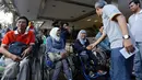 Direktur utama BSM Agus Sudiarto menyapa sejumlah penyandang disabilitas sebelum melepas keberangkatan penumpang mudik disabilitas pada acara gelar mudik Bank Syariah Mandiri (BSM) bersama disabilitas di Jakarta, Sabtu (2/7). (Liputan6.com/Faizal Fanani)