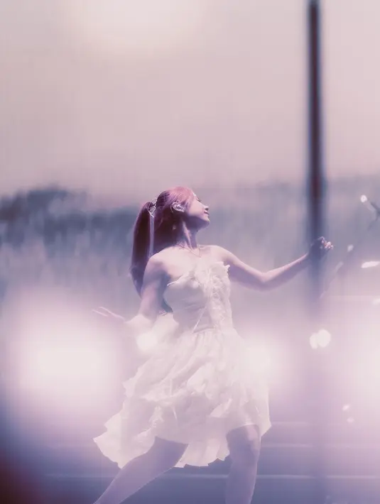 Potret memukau Nadin Amizah dengan strapless dress putih saat manggung. [Foto: Instagram/cakecaine]