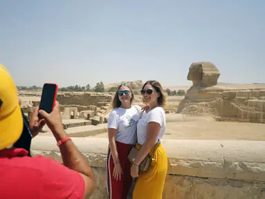 Sejumlah wisatawan berfoto di dekat Sfinks di Giza, Mesir (1/7/2020). Mesir pada Rabu (1/7) membuka kembali Museum Mesir, Piramida Giza, dan Kuil Luxor untuk kali pertama sejak ditutup akibat COVID-19 pada Maret lalu. (Xinhua/Ahmed Gomaa)