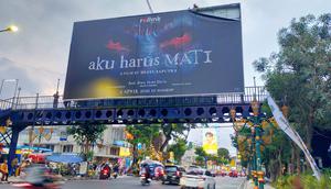 Seperti di Jakarta, Pemkot Malang melakukan penertiban terhadap materi iklan film horor berjudul ‘Aku Harus Mati, Jual Jiwa Demi Harta’ di JPO Kayutangan. (Foto: Liputan6.com/Zainul Arifin).