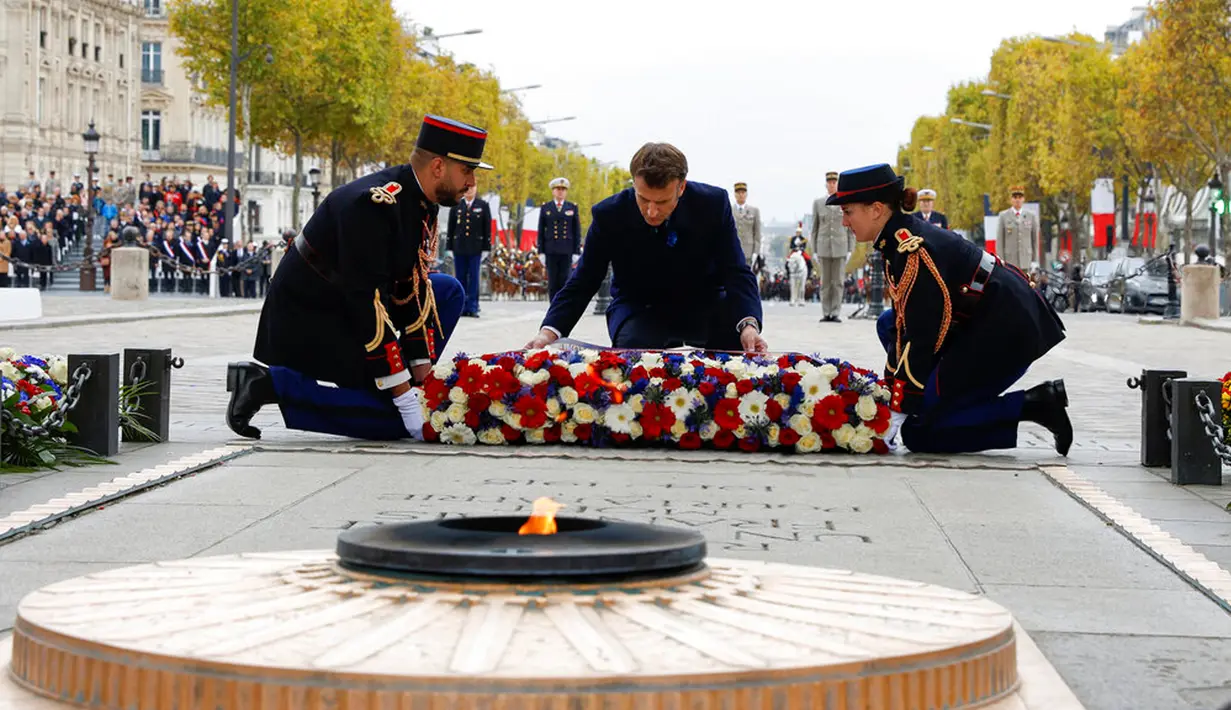 Presiden Prancis Emmanuel Macron meletakkan karangan bunga di Makam Prajurit Tak Dikenal saat upacara di Arc de Triomphe, Paris, Prancis, 11 November 2022. Upacara ini digelar untuk menandai peringatan 104 tahun Gencatan Senjata 11 November 1918 yang mengakhiri Perang Dunia I. (Gonzalo Fuentes/Pool via AP)