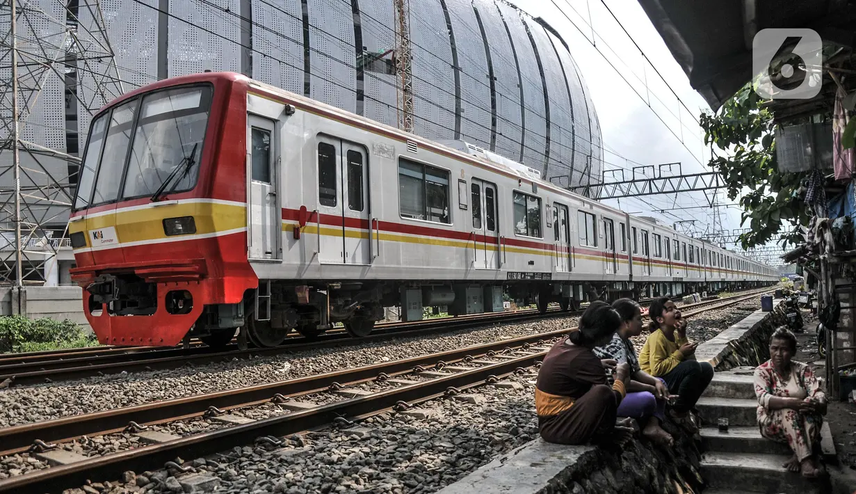 Rangkaian KRL melintasi permukiman liar Pela-Pela yang bersebelahan dengan Jakarta International Stadium (JIS), Kelurahan Papanggo, Tanjung Priok, Jakarta Utara, Selasa (22/2/2022). Warga berharap Pemprov DKI mendirikan tempat tinggal pengganti dan uang kompensasi. (merdeka.com/Iqbal S. Nugroho)