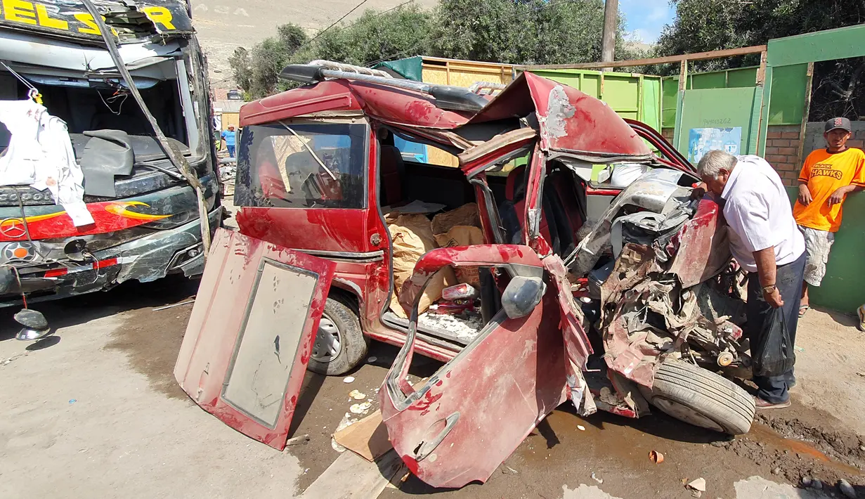 Seorang pria mengamati kondisi sebuah minivan yang ditabrak bus tingkat di daerah Arequipa, Peru, Senin (6/1/2020). Saat ini pihak operator bus masih melakukan investigasi terhadap kecelakaan maut itu. (Photo by Javier Casimiro / AFP)