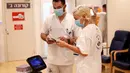Petugas medis Israel menguji sebuah robot Temi di Sheba Medical Center dekat Tel Aviv, Israel, (12/5/2020). Robot Temi kini digunakan di sejumlah rumah sakit dan pusat medis guna membantu meminimalkan kontak antarmanusia di tengah merebaknya wabah Covid-19. (Xinhua/Gil Cohen Magen)