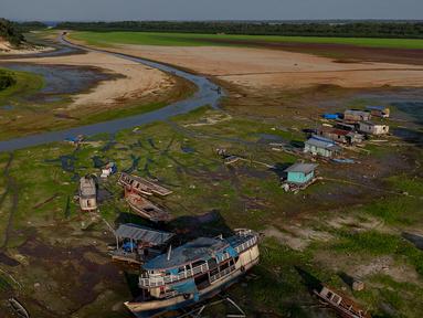 Perahu dan rumah-rumah terlihat terdampar di Danau Aleixo akibat kekeringan parah di sebelah barat Manaus, Negara Bagian Amazonas, Brasil, pada 20 September 2024. (MICHAEL DANTAS/AFP)