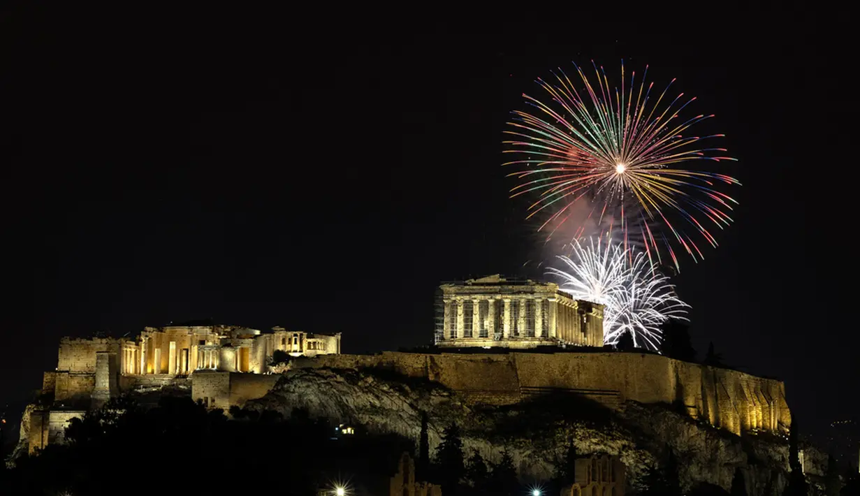 Kembang api meledak di atas kuil kuno Parthenon di Bukit Acropolis saat perayaan Tahun Baru di Athena, Yunani, Senin (1/1/2024). (AP Photo/Yorgos Karahalis)