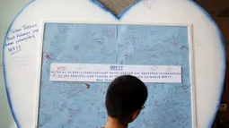 Seorang anak melihat-lihat pesan belasungkawa bagi para korban jatuhnya pesawat Malaysia Airlines MH-17 yang dipajang di Kuala Lumpur, (20/7/2014). (REUTERS/Olivia Harris)