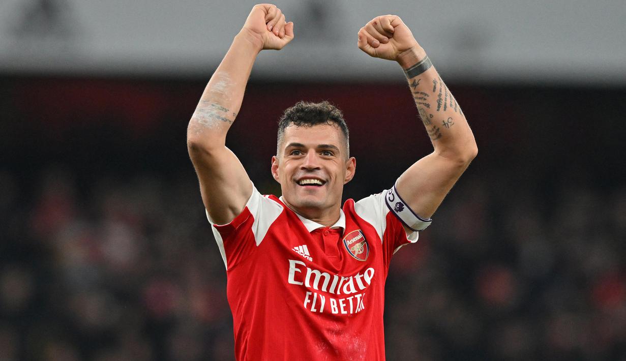 Selebrasi gelandang Arsenal, Granit Xhaka setelah mengalahkan Manchester United dalam laga Liga Inggris 2022/2023 di Emirates Stadium, London (22/1/2023). Masih menjadi pilihan utama Mikel Arteta dalam skuad Arsenal musim 2022/2023, pemain yang didatangkan dari Borussia Monchengladbach pada awal musim 2016/2017 ini bersanding dengan Mohamed Elneny sebagai pemain tertua kedua Arsenal dengan usia 30 tahun. (AFP/Glyn Kirk)