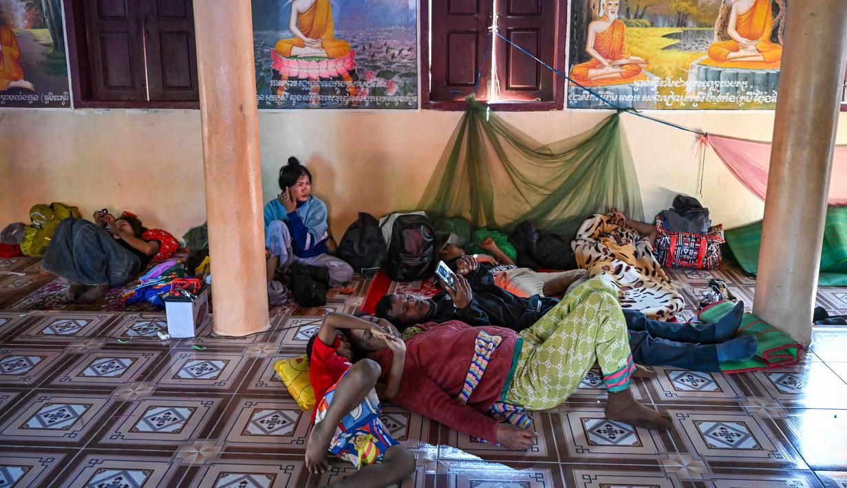 Sebelumnya, Kamboja dan Thailand telah menyepakati gencatan senjata tanpa syarat pada 28 Juli 2025, setelah baku tembak pada Mei 2025 menewaskan satu prajurit Kamboja, dan konflik meluas ke 12 titik perbatasan pada Juli 2025. Tampak dalam foto, warga beristirahat di dalam kuil setelah dievakuasi menyusul bentrokan di sepanjang perbatasan Kamboja-Thailand, di provinsi Siem Reap pada Selasa 9 Desember 2025. (TANG CHHIN SOTHY/AFP)