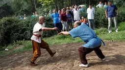 Master kungfu Li Liangui mempraktekan jurus kungfunya saat berlatih bersama rekannya di sebuah taman di Beijing, China, pada 30 Juni 2016. Selama 50 tahun, Li Liangui telah mendalami ilmu seni bela ini. (REUTERS/Kim Kyung-Hoon)