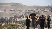 Orang-orang berjalan membawa tas-tas berisi bantuan kemanusiaan yang mereka terima di pusat distribusi yang dikelola oleh Yayasan Kemanusiaan Gaza (GHF) yang didukung Ameriks Serikat dan Israel, di koridor Netzarim, Nuseirat, Jalur Gaza tengah, pada 26 September 2025. (Eyad BABA/AFP)