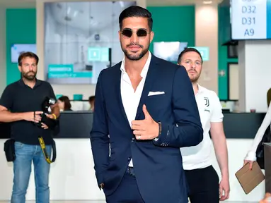 Pemain timnas Jerman, Emre Can menyapa awak media saat tiba untuk menjalani tes medis di J Medical di Turin, Italia, (21/6). Can menjalani tes medis untuk masuk ke klub Juventus. (Alessandro Di Marco/ANSA via AP)