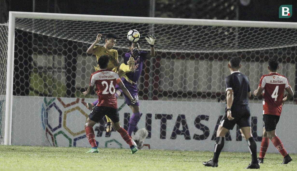 Striker Bhayangkara FC, Dendi Sulistyawan, berebut bola dengan kiper Madura United, Satria Tama, pada laga Liga 1 di Stadion PTIK, Jakarta, Kamis, (07/6/2018). Bhayangkara FC menang 1-0 atas Madura United. (Bola.com/M Iqbal Ichsan)