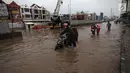 Pengendara mendorong sepeda motornya saat melintasi banjir di Jalan Boulevard Barat Raya, Kelapa Gading, Jakarta, Kamis (15/2). Hujan lebat sejak pagi hingga sore hari mengakibatkan sejumlah wilayah Ibu Kota terendam banjir. (Liputan6.com/Arya Manggala)