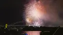 Kembang api meledak di atas Sydney Harbour saat perayaan awal Tahun Baru dimulai di Sydney, Minggu, 31 Desember 2023. (AP Photo/Mark Baker)