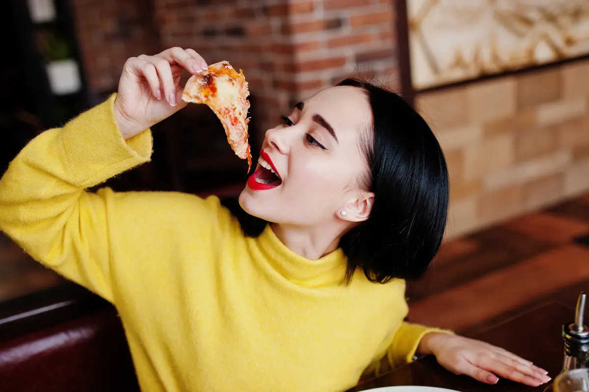 perempuan baju kuning makan dengan bahagia