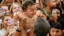 Presiden AS Barack Obama saat menggendong bayi yang menangis selama kunjungannya di Stasiun Udara Korps Marinir Iwakuni, Jepang (27/5). Kedatangan Obama ke Jepang untuk mennghadiri pertemuan G7. (REUTERS/Carlos Barria)