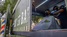 Seorang tukang cukur memotong rambut pelanggan di mobil van atau truck yang diubah menjadi barbershop di sebuah jalan di tengah pandemi virus corona COVID-19, di Mexico City, pada Minggu (6/9/2020). (Photo by CLAUDIO CRUZ / AFP)