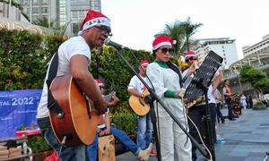 Musisi mengelar pertunjukan musik bernuansa Natal di jalur Pedestrian Bundaran HI, Jakarta Pusat, Selasa (20/12/2022). Pergelaran musik bernuansa Natal tersebut sebagai bentuk pertunjukan untuk menghibur warga yang melintas di Kawasan itu. (Liputan6.com/Angga Yuniar)