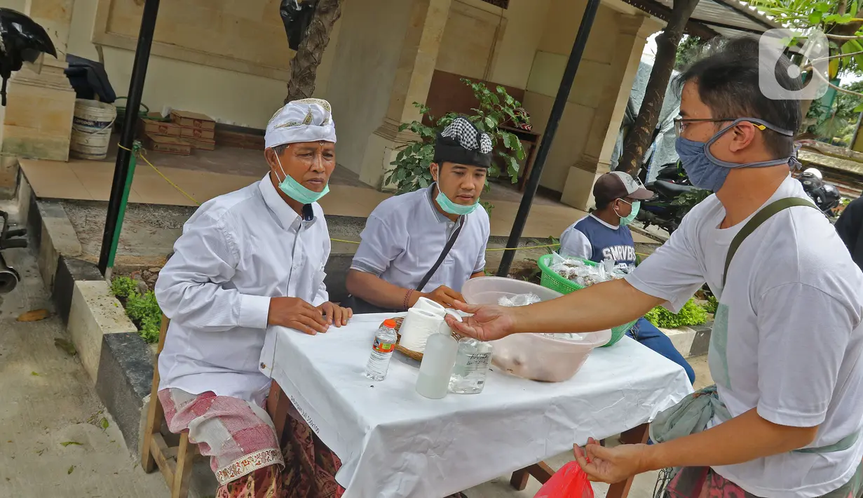 Warga saat tiba di Pura Aditya Jaya di Jakarta, Selasa (24/3/2020). Ibadah hari suci Nyepi Tahun Baru Saka 1942 di Pura Aditya Jaya tidak menyelenggarakan persembahyangan, namun untuk sembahyang dibatasi dalam mencegah penularan penularan Covid-19. (Liputan6.com/Herman Zakharia)