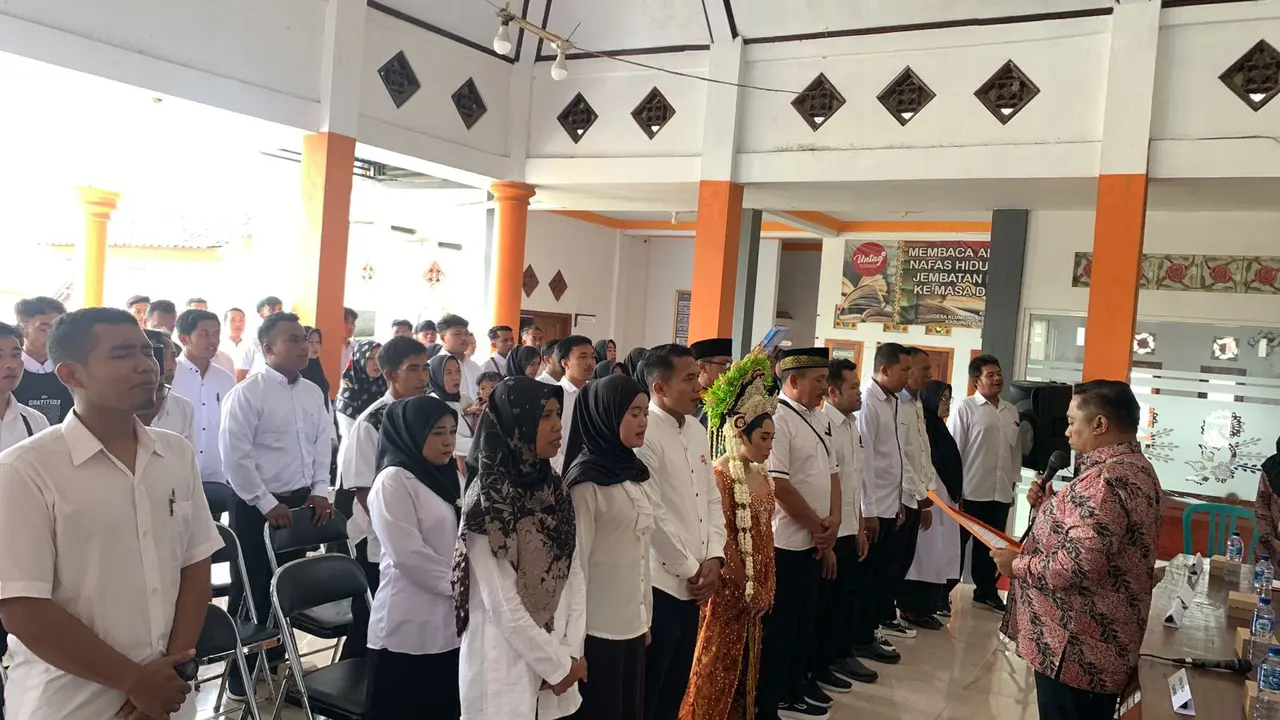 Lis Watiningsih (tengah) mengikuti pelantikan anggota KPPS di Balai Desa Kluncing Banyuwangi yang bersamaan dengan hari resepsi pernikahanya. (Istimewa)