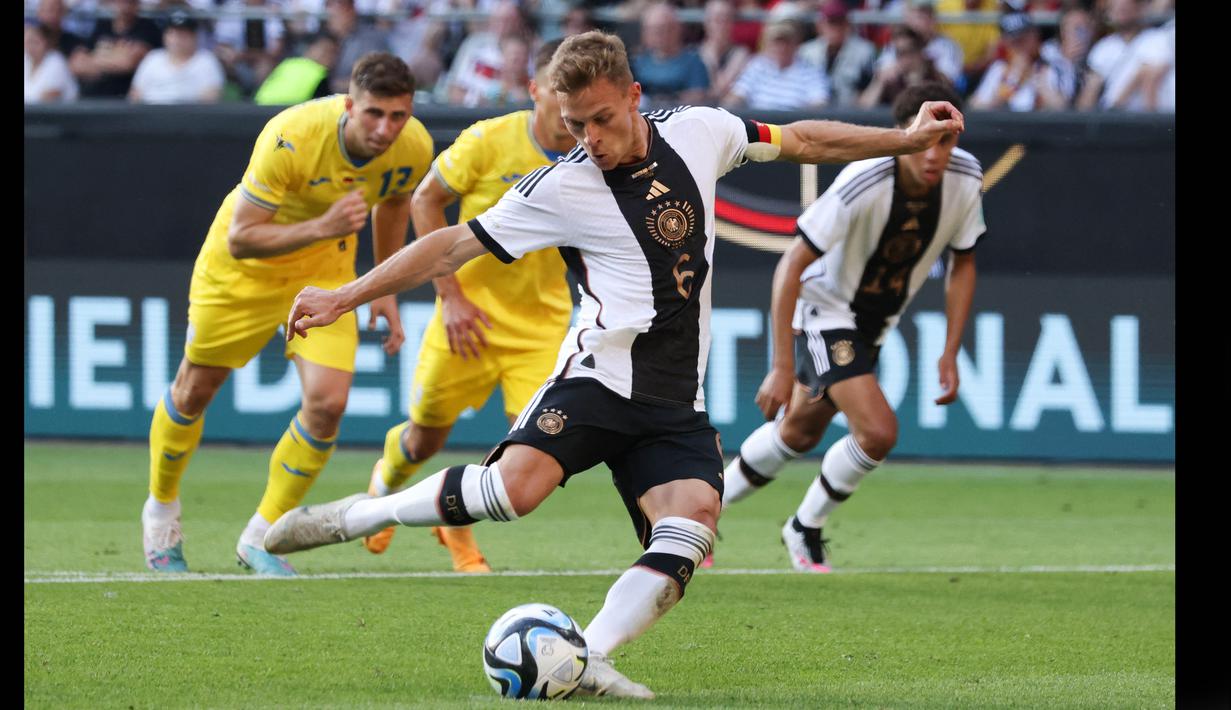 Pemain Timnas Jerman, Joshua Kimmich, menendang bola dari titik penalti yang membuahkan gol dalam laga persahabatan internasional FIFA Matchday 2023 yang digelar di Weserstadion, Bremen, Senin (12/6/2023) malam WIB. (AFP/Focke Strangmann)