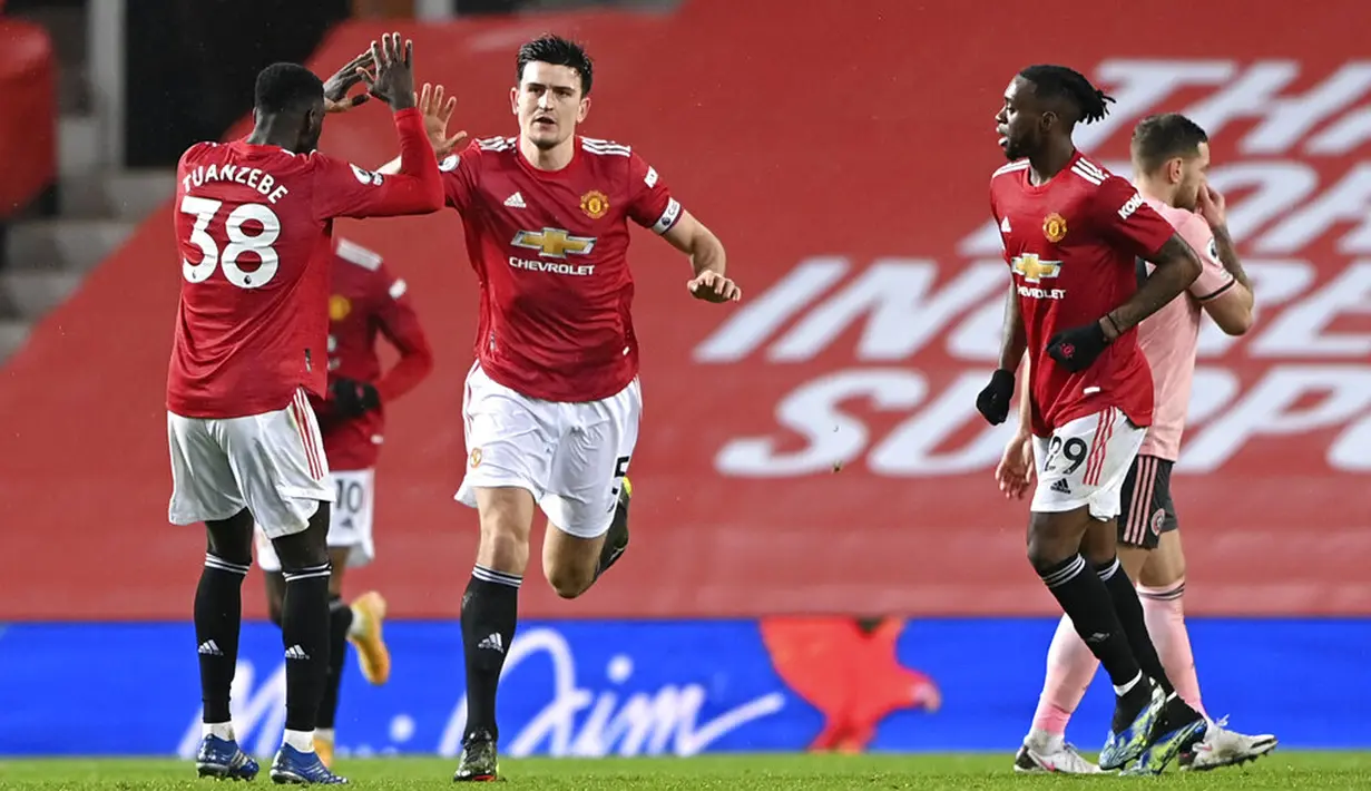 Pemain Manchester United Harry Maguire (tengah) diberi selamat oleh rekan setimnya Axel Tuanzebe (kiri) usai mencetak gol ke gawang Sheffield United pada pertandingan Liga Inggris di Old Trafford, Manchester, Inggris, Rabu (27/1/2021). Sheffield United menang 2-1. (AP Photo/Laurence Griffiths, Pool)