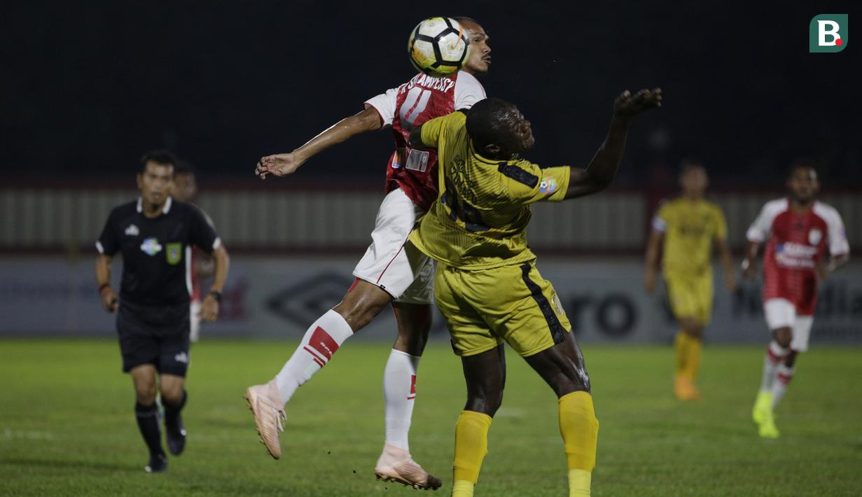 Bek Persipura, Ricardo Salampessy, duel udara dengan striker Bhayangkara FC, Herman Dzumafo, pada laga Liga 1 Indonesia di Stadion PTIK, Jakarta, Senin (18/11). Bhayangkara menang 2-0 atas Persipura. (Bola.com/Vitalis Yogi Trisna)